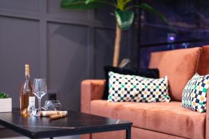 a living room with a couch and a table with wine glasses at MY Luxury Suites - Old Town Rethymno in Rethymno Town