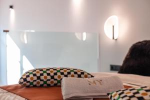 a bed with two pillows and a towel on it at My Luxury Downtown Vibe Suites in Rethymno