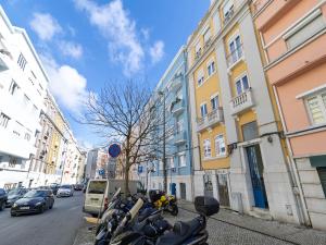 a row of motorcycles parked on a street next to buildings at Akicity Lisboa Iris in Lisbon