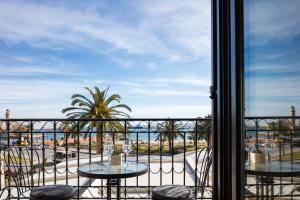 a balcony with two tables and a view of the ocean at MY Luxury Suites - Old Town Rethymno in Rethymno Town