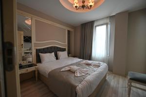 1 dormitorio con 1 cama con toallas en Albatros İstanbul en Estambul