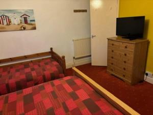 a bedroom with a bed and a television on a dresser at Argyll guest house in Blackpool