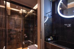 a bathroom with a shower and a sink and a mirror at My Luxury Downtown Vibe Suites in Rethymno