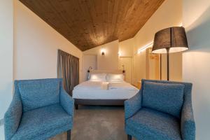 1 dormitorio con 1 cama y 2 sillas azules en Agriturismo B&B Caffè e Vino en Sondrio