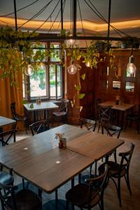 a dining room with tables and chairs and plants at Penzion Pivovar Volt in Jablonec nad Nisou