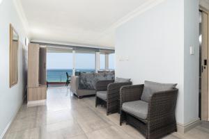 a living room with chairs and a view of the ocean at Chakas Cove 38 in Ballito