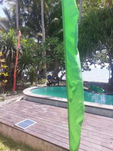 una terraza de madera junto a una piscina en Bali Homestay en Tejakula