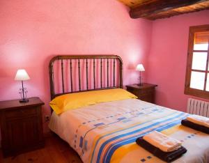 a bedroom with a bed and two tables and two lamps at Cal Jep Costa in Saldés