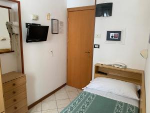 a small bedroom with a bed and a television at Hotel Tre Grazie in Rimini