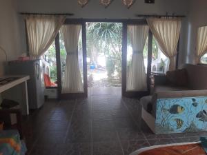 sala de estar con puertas correderas de cristal y sofá en Bali Homestay en Tejakula
