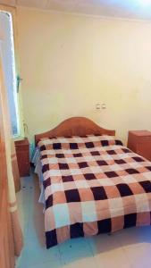 a bedroom with a bed with a checkered blanket at Moji pension in Addis Ababa