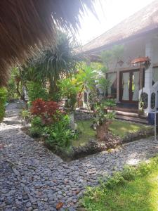 una casa con un jardín delante de ella en Bali Homestay en Tejakula