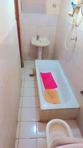 La salle de bains est pourvue d'une baignoire, d'un lavabo et de toilettes. dans l'établissement Moji pension, à Addis-Abeba