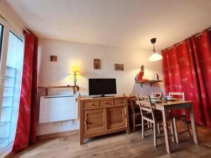 a room with a desk with a television and a table with chairs at Meije 5 - C3 - Appart 4 pers proche pistes in Les Deux Alpes