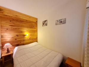 a bedroom with a white bed and a wooden wall at Meije 5 - C3 - Appart 4 pers proche pistes in Les Deux Alpes