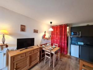 a living room with a desk with a television and a kitchen at Meije 5 - C3 - Appart 4 pers proche pistes in Les Deux Alpes