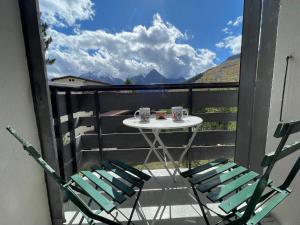 a table and two chairs on a balcony with a view at Meije 5 - C3 - Appart 4 pers proche pistes in Les Deux Alpes