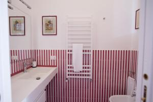 uma casa de banho com uma parede com riscas vermelhas e brancas em Beatrice Apartment Sea View em Vietri