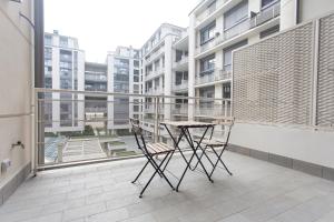 ein Apartment-Balkon mit einem Tisch und Stühlen darauf in der Unterkunft Unico Studios in Mailand
