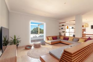 a living room with a couch and a large window at Tiny Whale Lodge, a unique space for groups in Bensafrim
