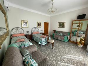 a bedroom with two beds and a couch and a mirror at Dimora Cadò Alloggio Turistico Privato in Taranto