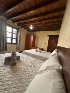 Duas camas grandes num quarto com uma janela em Casa Los Héroes em Antigua Guatemala