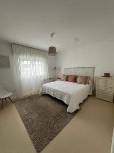 ノアリャにあるVivienda Cousillasの白いベッドルーム(ベッド1台、ラグ付)