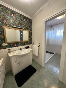 La salle de bains est pourvue d'un lavabo, d'un miroir et d'une douche. dans l'établissement Vivienda Cousillas, à Noalla