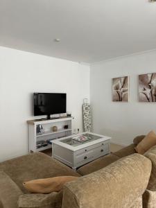 a living room with a couch and a tv at Vivienda Cousillas in Noalla