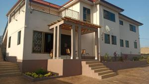 a white house with a porch and stairs at Villa at Grace in Cape Coast