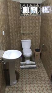 a bathroom with a toilet and a sink at Villa at Grace in Cape Coast