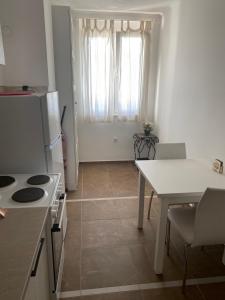cocina con mesa, nevera blanca y mesa en Apartment Bruno NICE PLACE, en Belgrado