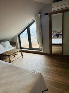 a bedroom with a bed and a table and a window at Hotel Spa Norat Torre Do Deza 4* Superior in Lalín