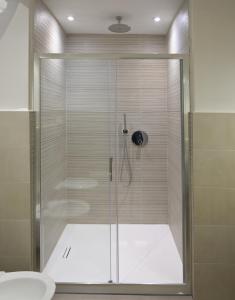 una doccia con porta in vetro in bagno di Casa via Pascoli a Arzachena
