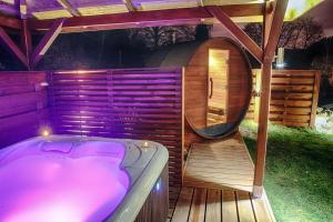 uma sauna com uma banheira de hidromassagem e um espelho redondo em Le Clos des Thermes Suites de Luxe avec wellness privatif em Chaudfontaine