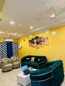 a living room with couches and a laptop on a table at Villa meublée climatisé en cours unique in Ouagadougou