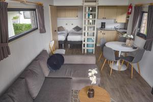 a living room and kitchen in a tiny house at Amici Camping Urlaub am Effelder Waldsee in Wassenberg