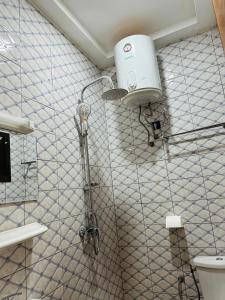 a shower in a bathroom with a toilet at Villa meublée climatisé en cours unique in Ouagadougou