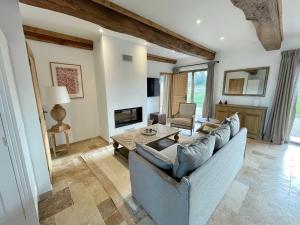 ein Wohnzimmer mit einem Sofa und einem Tisch in der Unterkunft Maison Morny Your Exquisite Retreat near Deauville in Cricquebœuf