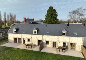 ein großes Backsteingebäude mit grauem Dach in der Unterkunft Maison Morny Your Exquisite Retreat near Deauville in Cricquebœuf