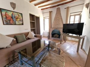 a living room with a couch and a fireplace at Manzal Lahbab, 2Villas 2Bungalows 2Piscines et Jardins in Marrakech