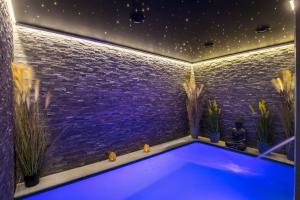 uma piscina num quarto com plantas em Le Clos des Thermes Suites de Luxe avec wellness privatif em Chaudfontaine