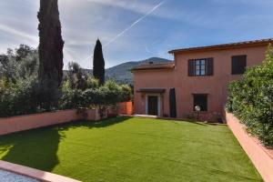 a yard with a house with a green lawn at Duca House in San Giovanni