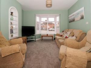 a living room with two couches and a flat screen tv at Lambs Fold in Malton