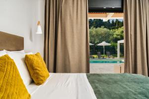 a bedroom with a bed and a view of a pool at Valeria Private Villa in Plános