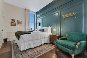 a bedroom with a bed and a green chair at The Historic Grand Canyon Hotel in Williams