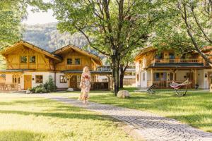 a woman standing in front of a house at feelfree - Natur & Aktiv Resort Ötztal in Oetz