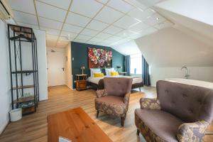 Cette chambre comprend un lit, deux chaises et une table. dans l'établissement De Klomp Charme Hotel & Restaurant, à Vilsteren