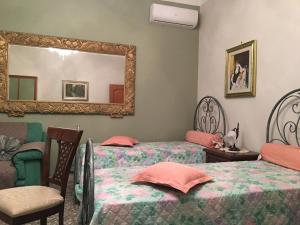 a bedroom with two beds and a mirror at Dimora Cadò Alloggio Turistico Privato in Taranto