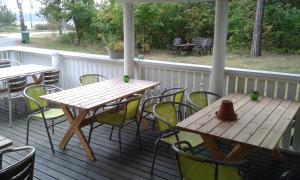 - une table et des chaises en bois sur une terrasse couverte dans l'établissement Lilla Hotellet, à Västervik